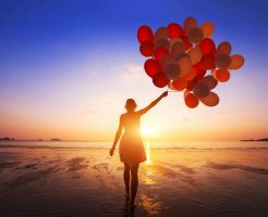 自由を手に入れる inspiration, joy and happiness concept, silhouette of woman with many flying balloons on the beach